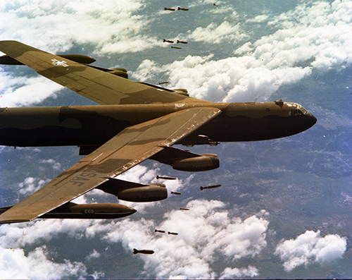 An image of a B52 bomber aircraft airborne dropping bombs